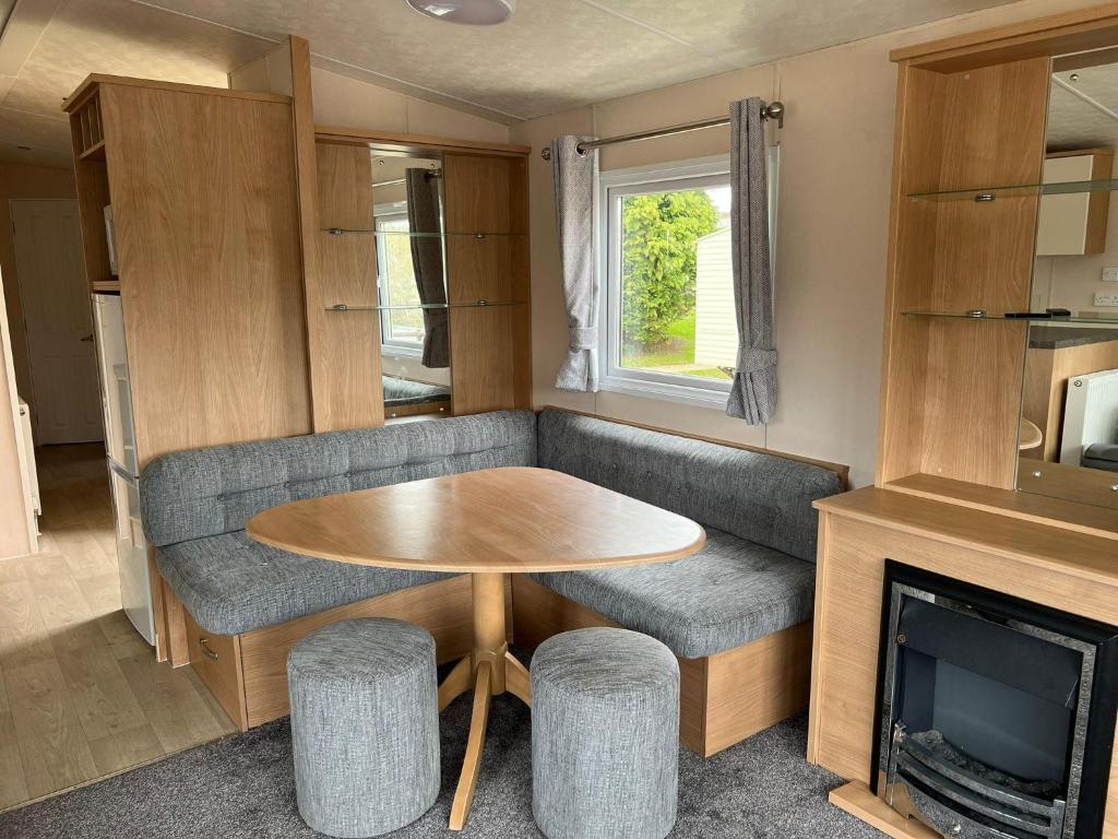 a living room with a table and a couch and a tv at Lovely Caravan At Lower Hyde Holiday Park, Isle Of Wight Ref 24001g in Shanklin