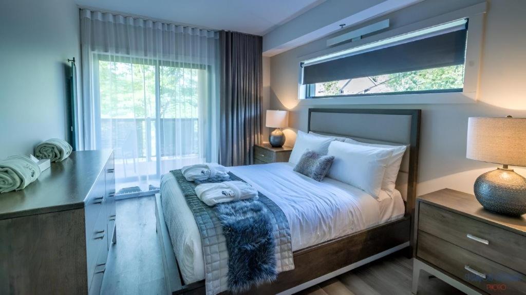 1 dormitorio con 1 cama, escritorio y ventana en Château Morritt en Mont-Tremblant