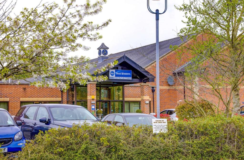 un parking avec des voitures garées devant un bâtiment dans l'établissement Best Western Appleby Park Hotel, à Tamworth