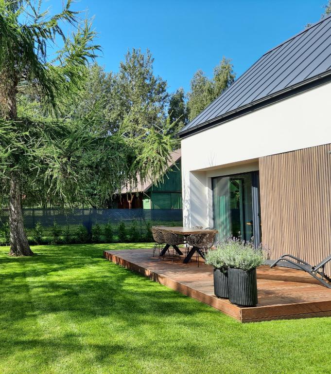 a wooden deck with a picnic table in a yard at Sosnowe Zacisze in Sasino