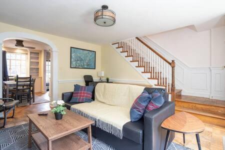 a living room with a couch and a staircase at Spacious 4BR CozySuites in Old Town Alexandria in Alexandria