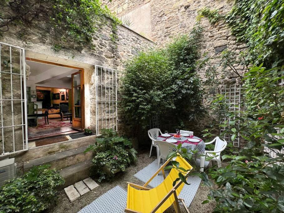 un patio avec une table et des chaises devant un bâtiment dans l'établissement Tranquil apt with patio, Pézenas historic centre, à Pézenas