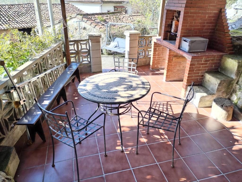 a patio with a table and chairs and a grill at Casa Molily in Llanes