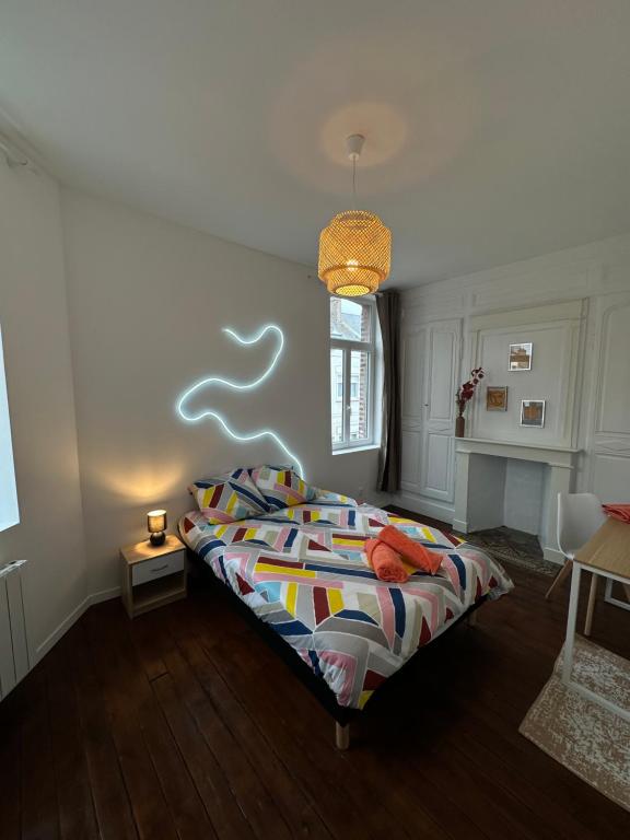 1 dormitorio con 1 cama con un edredón colorido en La chambre jaune, en Amiens