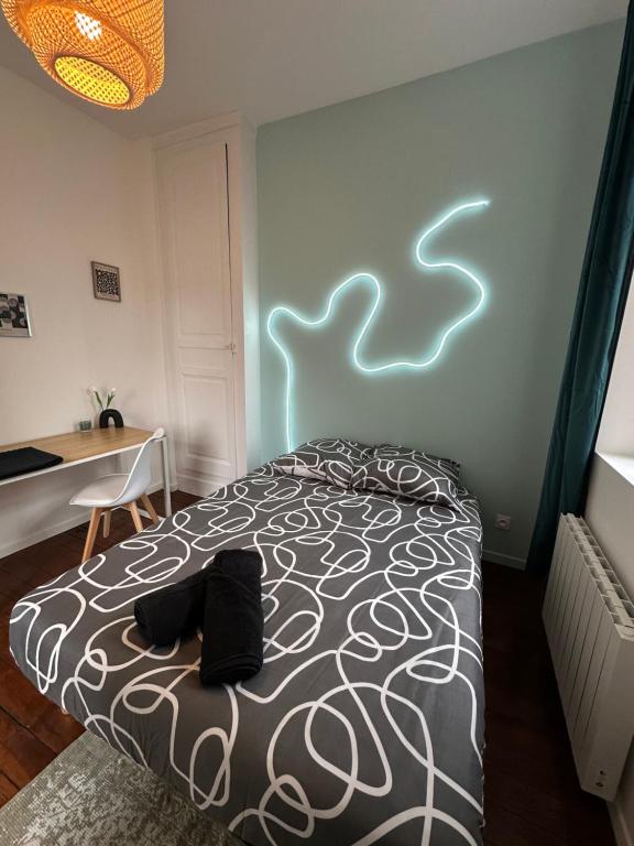 1 dormitorio con 1 cama con luz en la pared en La chambre turquoise, en Amiens