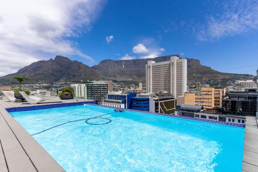a swimming pool on top of a building with a mountain at The Tokyo 710 in Cape Town