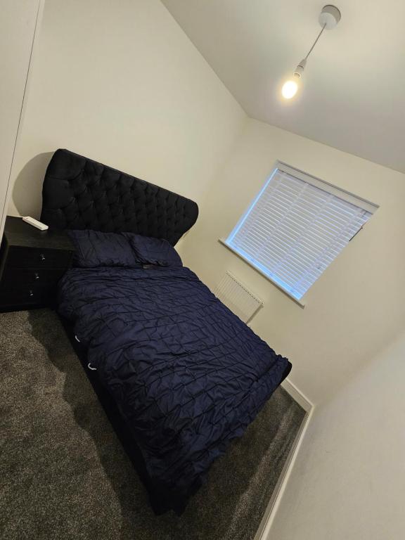 1 dormitorio con 1 cama con edredón azul y ventana en guest room in crewe en Church Coppenhall