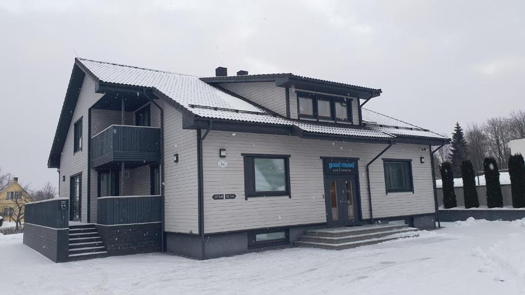 una casa sentada en la nieve en un patio en good mood guesthouse, en Otepää