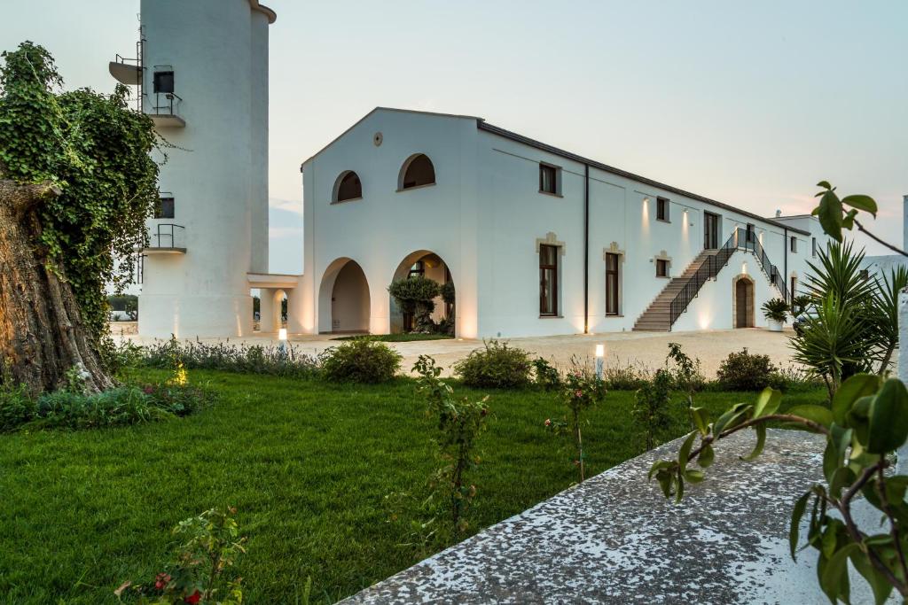 un gran edificio blanco con un patio de césped en Masseria Martellotta, en Palagianello