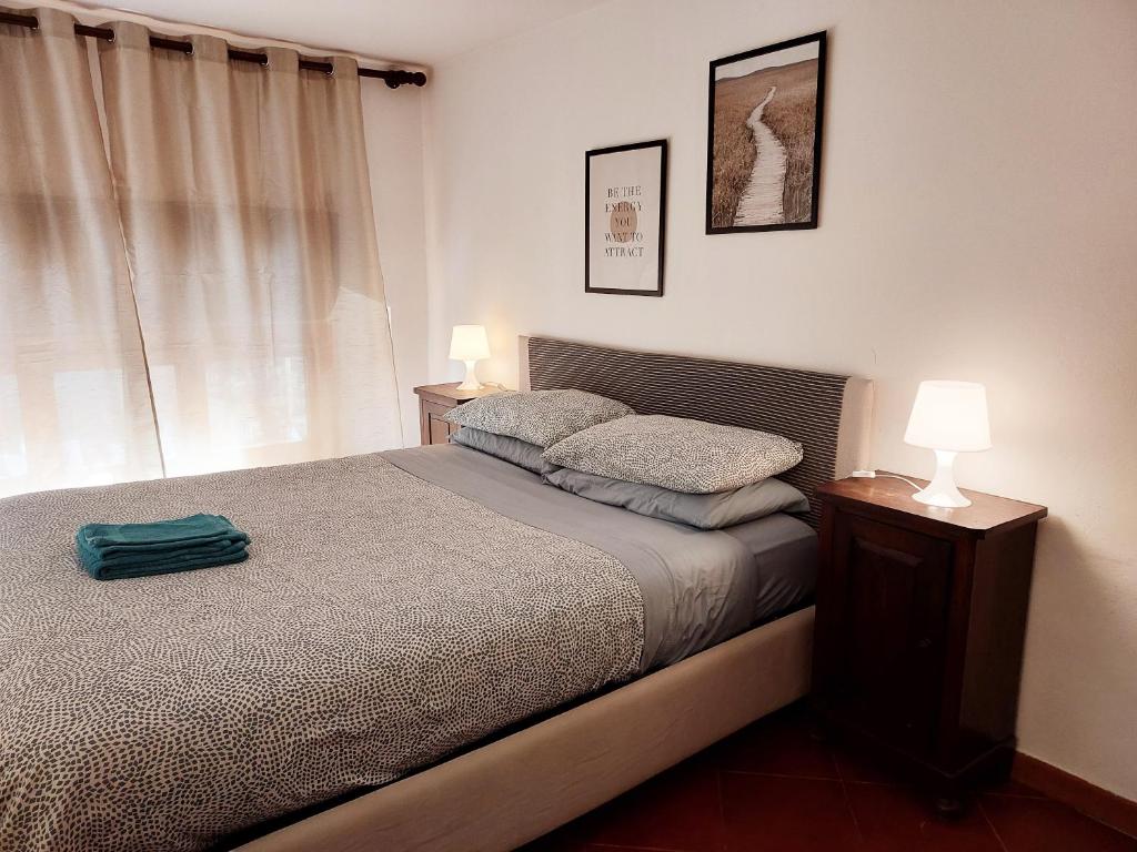 a bedroom with a bed and a lamp and a window at The Smart Choice Apartments in Florence