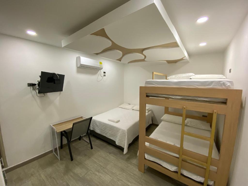a small room with two bunk beds and a desk at Hotel Dubai Deluxe Curumani in Curumaní