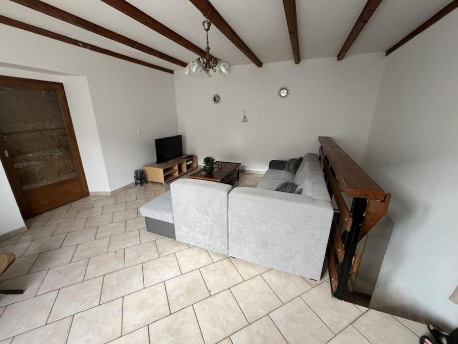 a living room with a couch and a tv at Maison proche de la campagne au calme 7-8 personnes in Cambon