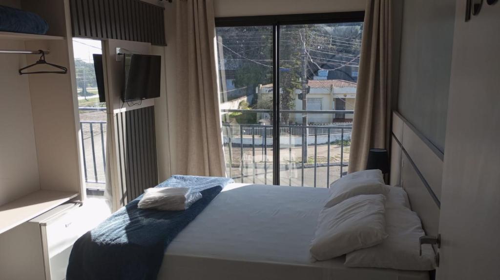 um quarto com uma cama e uma grande janela em HOTEL BARLOS ADUANA em Uruguaiana