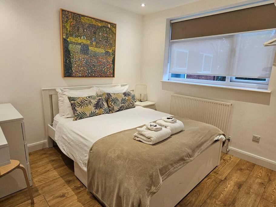 1 dormitorio con 1 cama con toallas en Neon Heights 2 bed Luton town centre en Luton