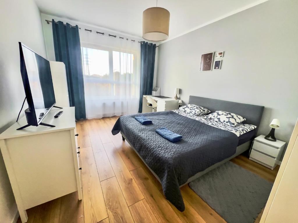 - une chambre avec un lit et un bureau avec une télévision dans l'établissement 304 BALTICA Hallera 223 Apartamenty zresetuj się w Gdańsku blisko morza, à Gdańsk