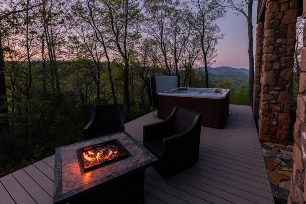 d'une terrasse avec un bain à remous et un foyer extérieur. dans l'établissement Black Mountain Log Cabin Secluded, Pet-friendly 3BD with Hot Tub & Views!, à Black Mountain