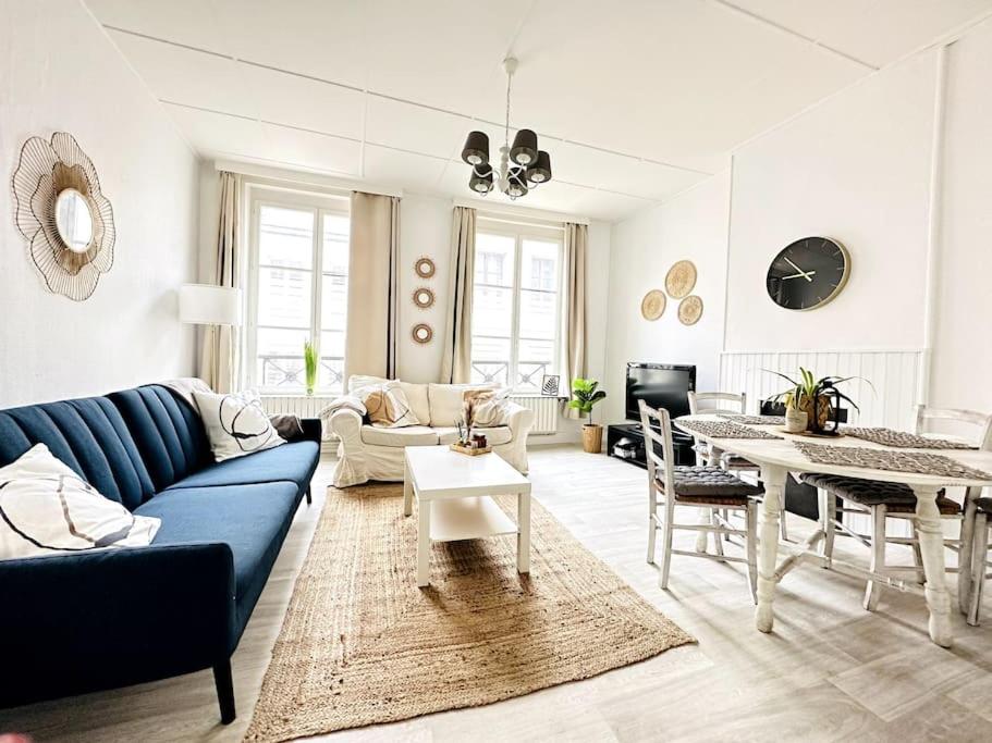 ein Wohnzimmer mit einem blauen Sofa und einem Tisch in der Unterkunft L'échappée Belle in Laon