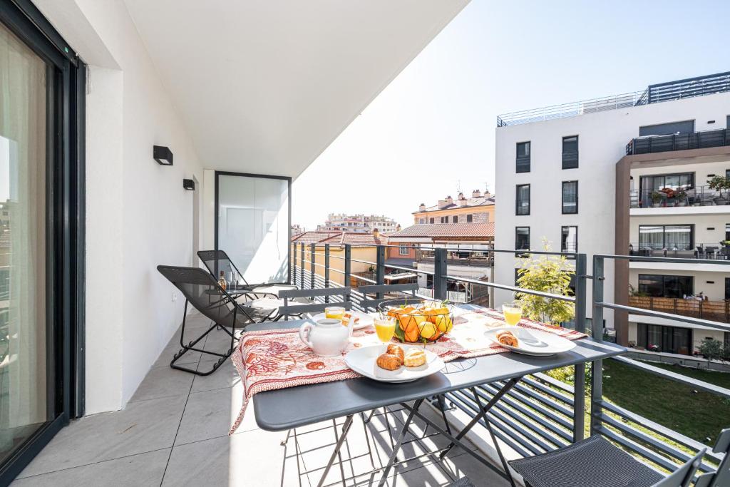 a balcony with a table with food on it at Queen Riviera : climatisation, parking, terrasse in Menton