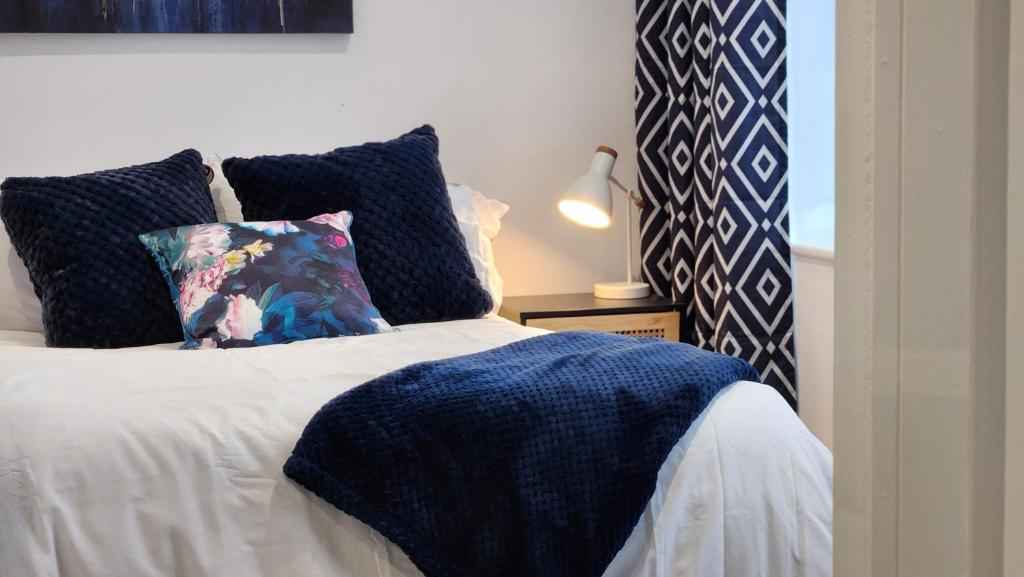 a bed with a blue blanket and pillows on it at 1 Bedroom Apartment Urban Stay in Peterborough