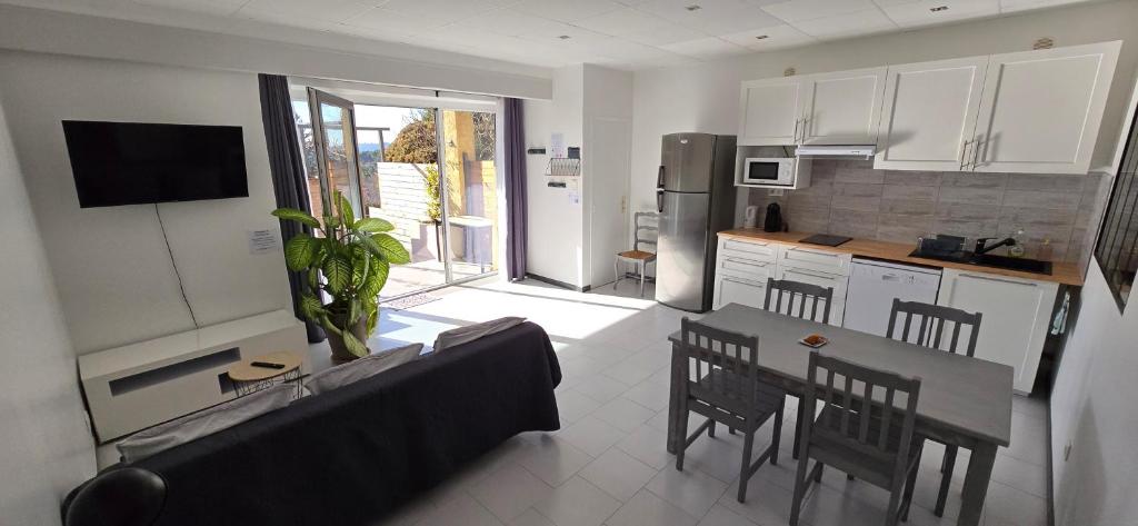 a kitchen and living room with a couch and a table at Ô Phil du Vent' in Ventabren