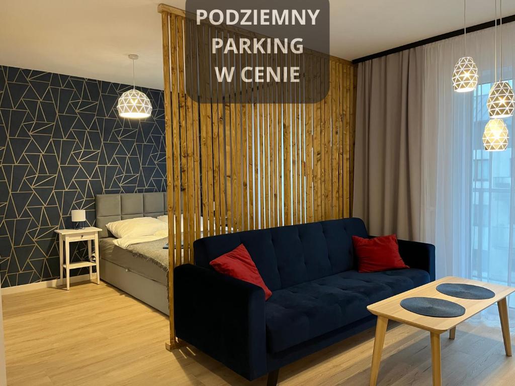 a living room with a couch and a bedroom at Apartament Studio Centrum in Koszalin