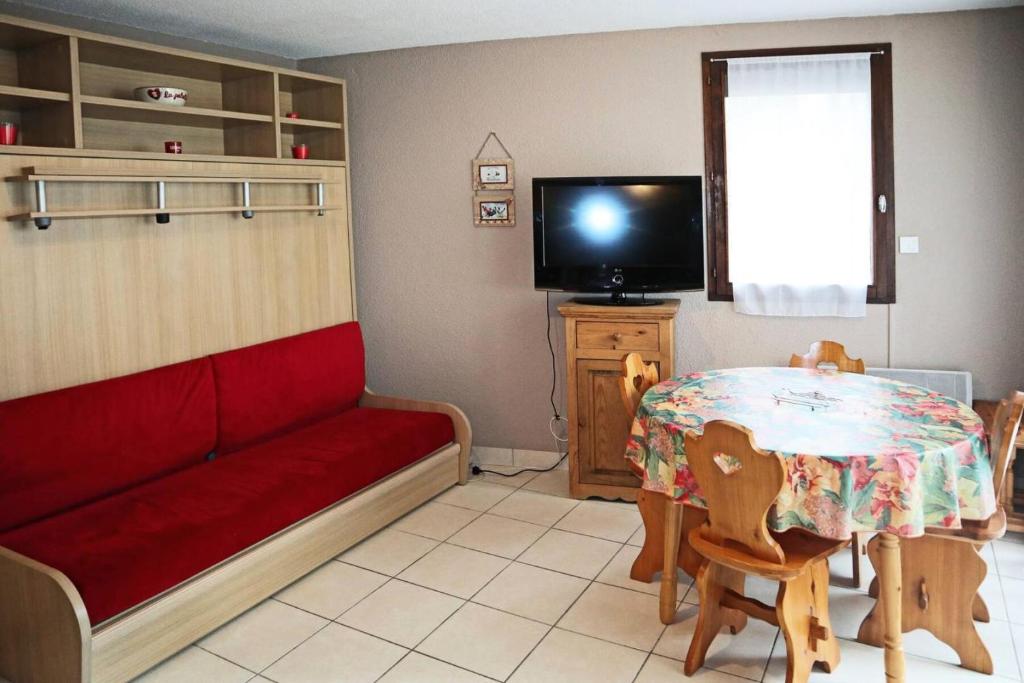 un salon avec un canapé rouge et une table dans l'établissement Résidence Les Flocons - Studio pour 4 Personnes MAE-7324, aux Orres