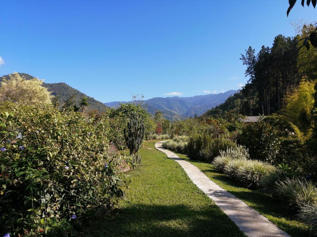 a path through a garden with mountains in the background at La Cima del Mundo in Chimirol