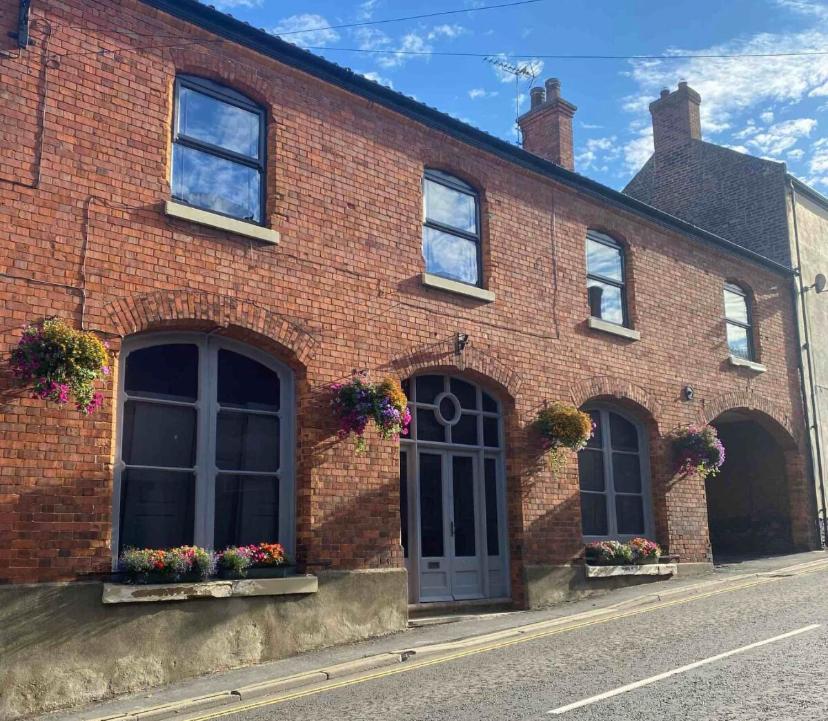 a red brick building with windows and flower boxes at Caistor Bed & Breakfast in Caistor