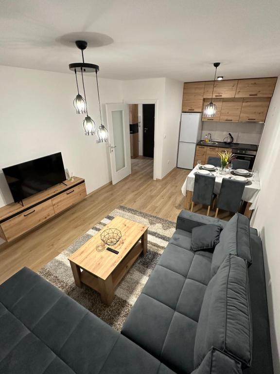 - un salon avec un canapé et une table dans l'établissement Lux Apartment 31, à Lukavica