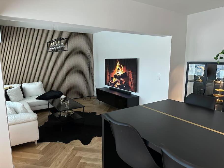 a living room with a table and a fireplace at Rewell Suite - Central location and nice view! in Vaasa