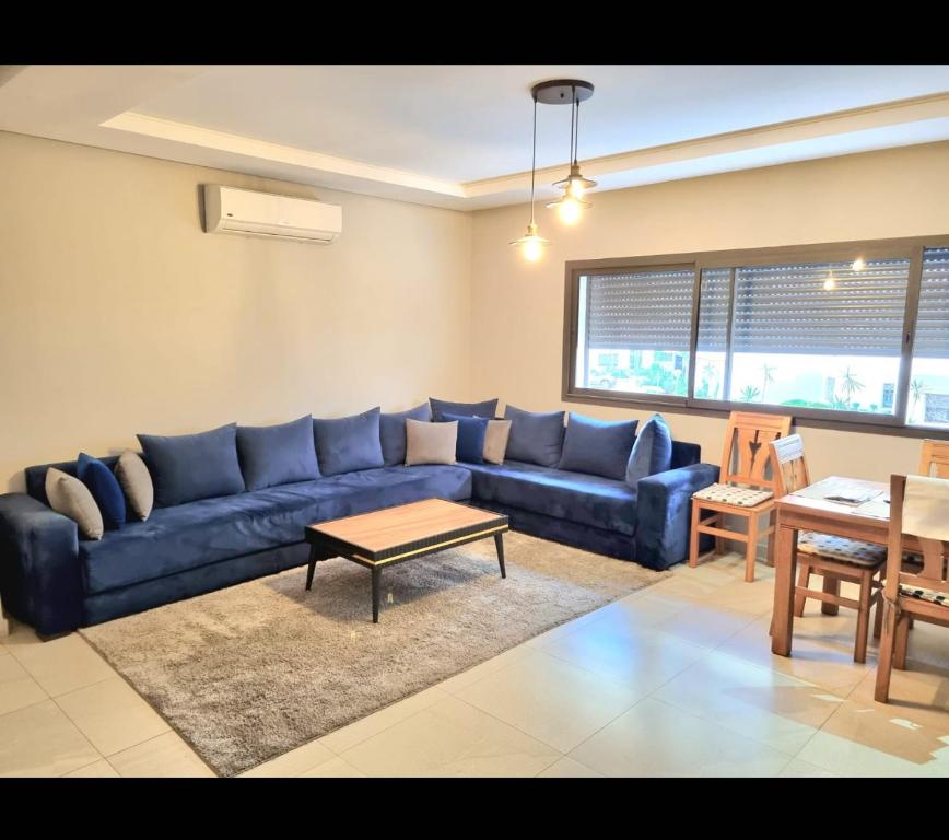 a living room with a blue couch and a table at Yasmine agadir Marocko in Agadir