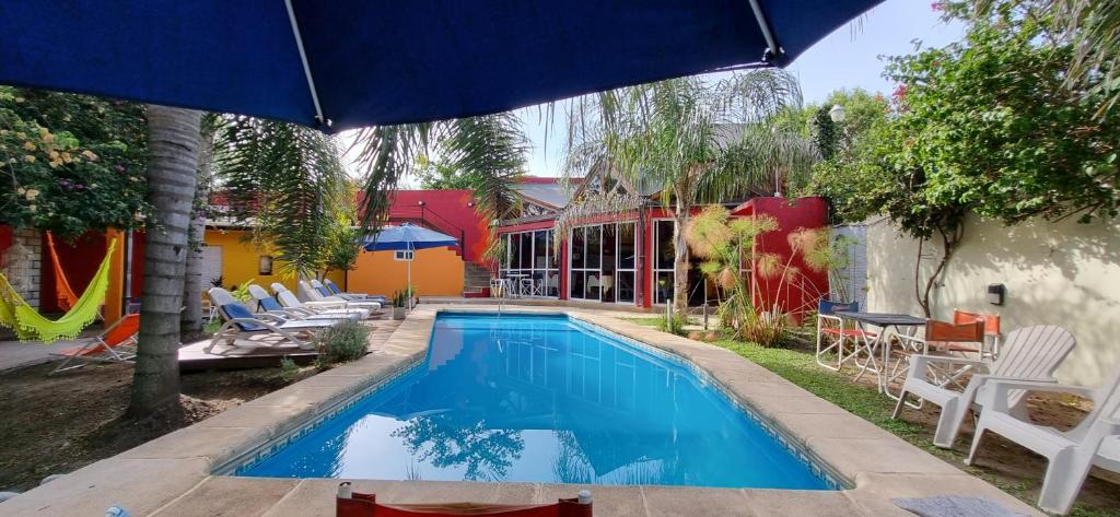 a swimming pool with chairs and an umbrella at Costas del Paraiso in Colón