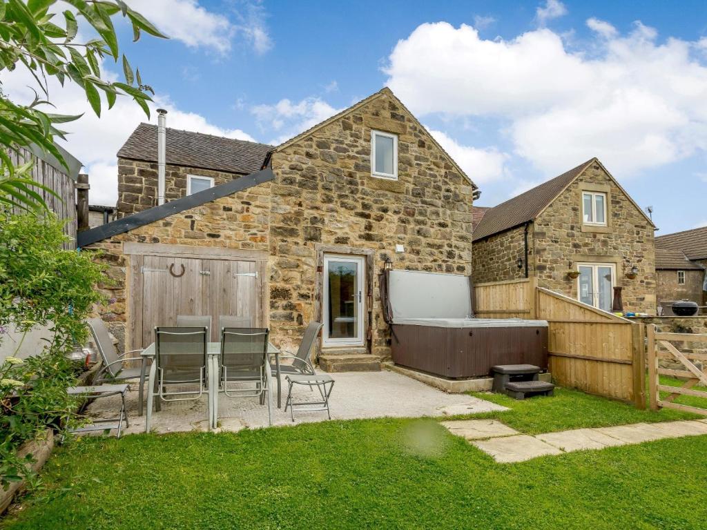 a stone house with a garden and a bath tub at 3 Bed in Crich 78717 in Crich