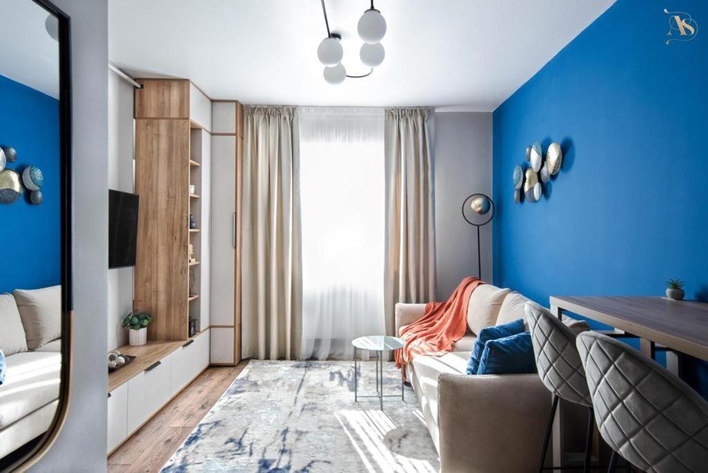 a living room with blue walls and a couch and a table at Cazare Poiana in Braşov