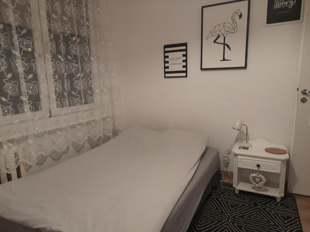 トルンにあるMieszkanie 4-pokojowe w Toruniu przy UMKの小さなベッドルーム(ベッド1台、テーブル付)