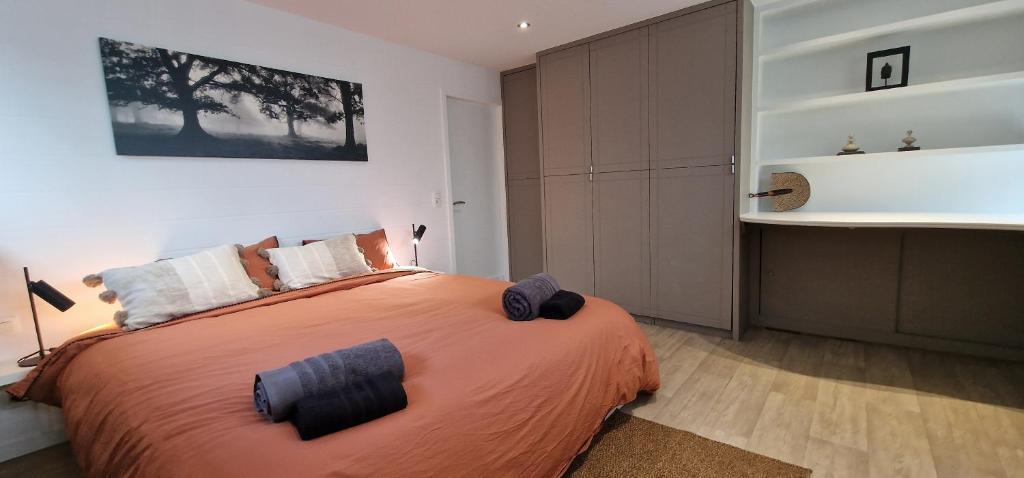 um quarto com uma grande cama laranja num quarto em La Fauvette em Embourg