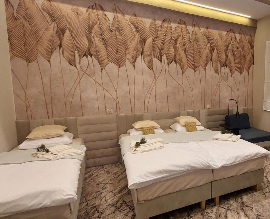 Duas camas num quarto com uma parede com penas em KOLUMNA HOUSE domek noclegowy z prywatną sauną em Lask