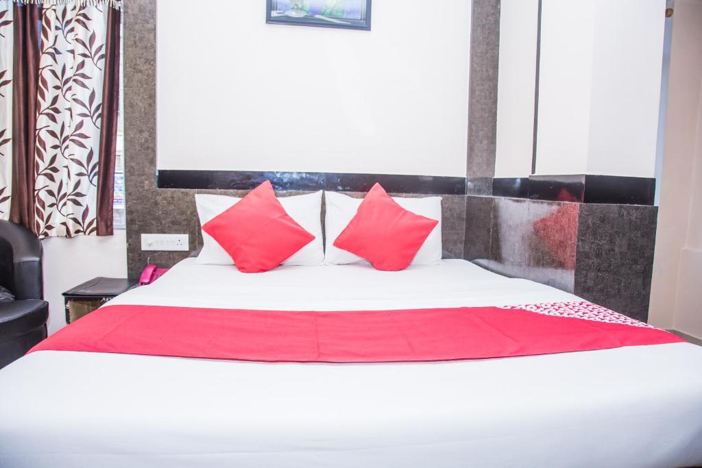 a bedroom with a large bed with red pillows at OYO Hotel Executive Inn in Agartala