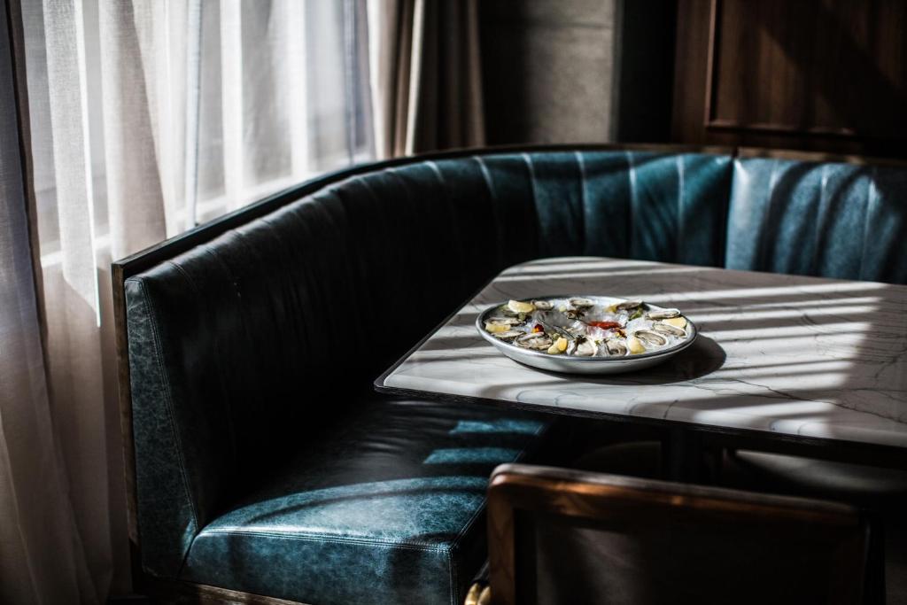 a plate of food on a table on a leather chair at Thompson Nashville, by Hyatt in Nashville