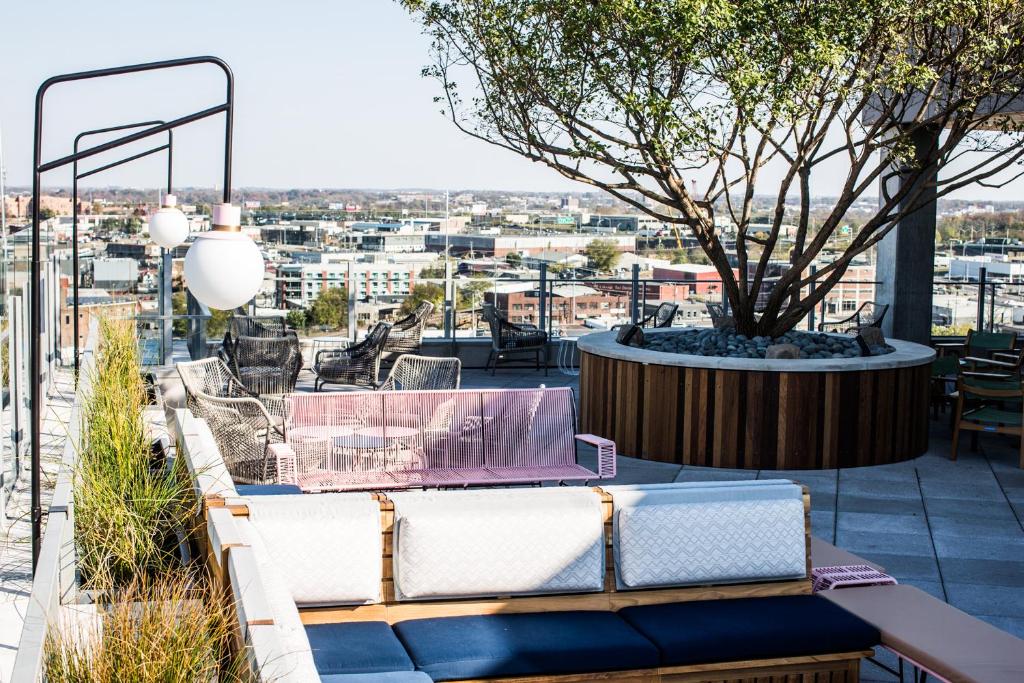 a patio with a table and chairs and a tree at Thompson Nashville, by Hyatt in Nashville