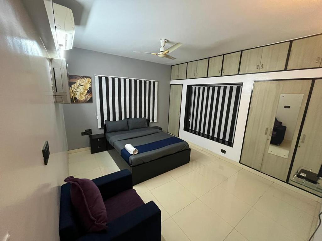 a bedroom with a bed and a couch in it at Fully Furnished Luxurious Terrace apartment in Pune