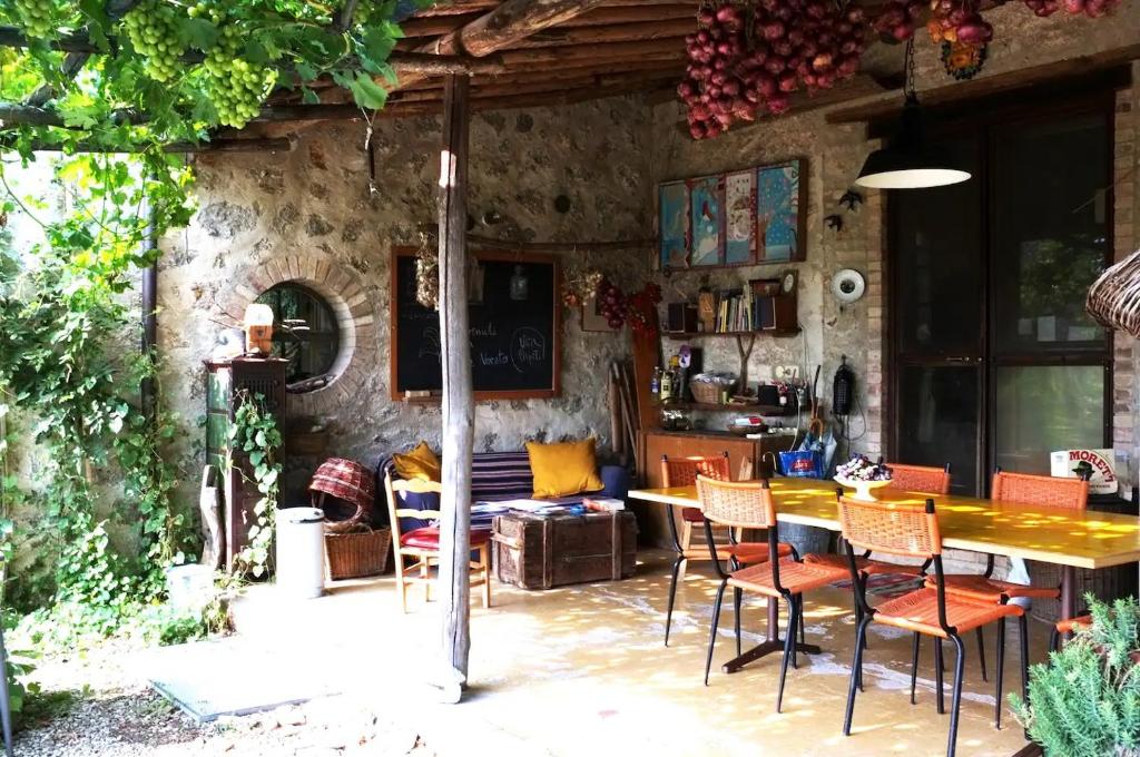 d'une terrasse avec une table et des chaises en bois. dans l'établissement private room with own bathroom at Podere Noceto, à Grotti