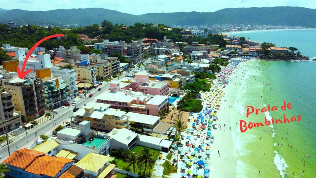 eine Luftansicht auf einen Strand mit einer Menschenmenge in der Unterkunft 1029 - Apartamento no centro de Bombinhas - Residencial estrela do mar 2 104 A in Bombinhas