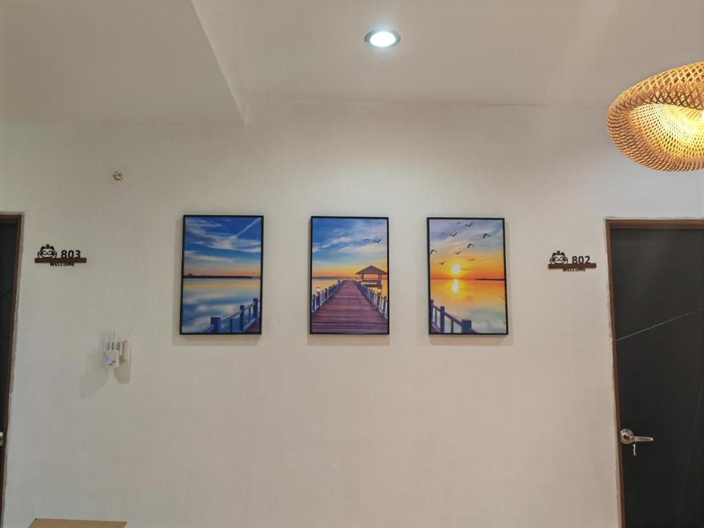 a group of four pictures on a wall at Cozy Roomstay Padang Serai in Padang Serai