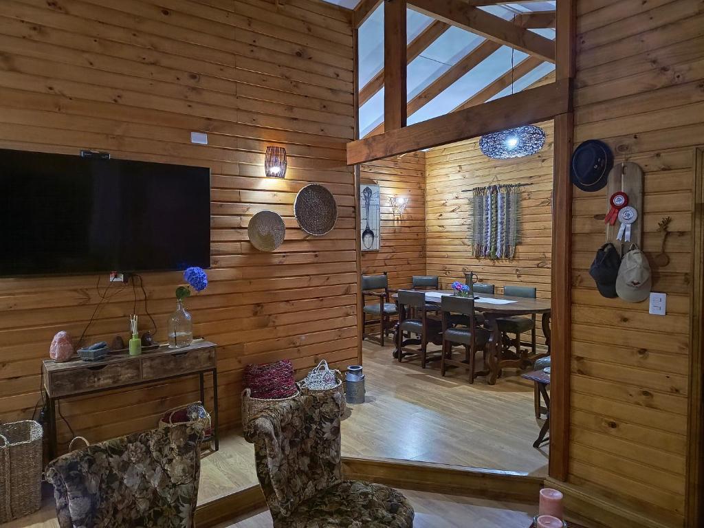 a living room with a television and a dining room at Casa Bella Vista Futrono in Futrono
