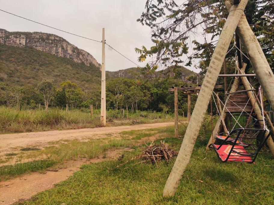 um balanço num poste ao lado de uma estrada de terra batida em Casa Jasmim em Cavalcante