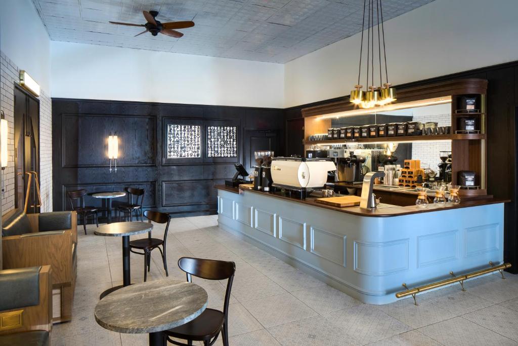 a restaurant with a bar and some tables and chairs at Thompson Nashville, by Hyatt in Nashville