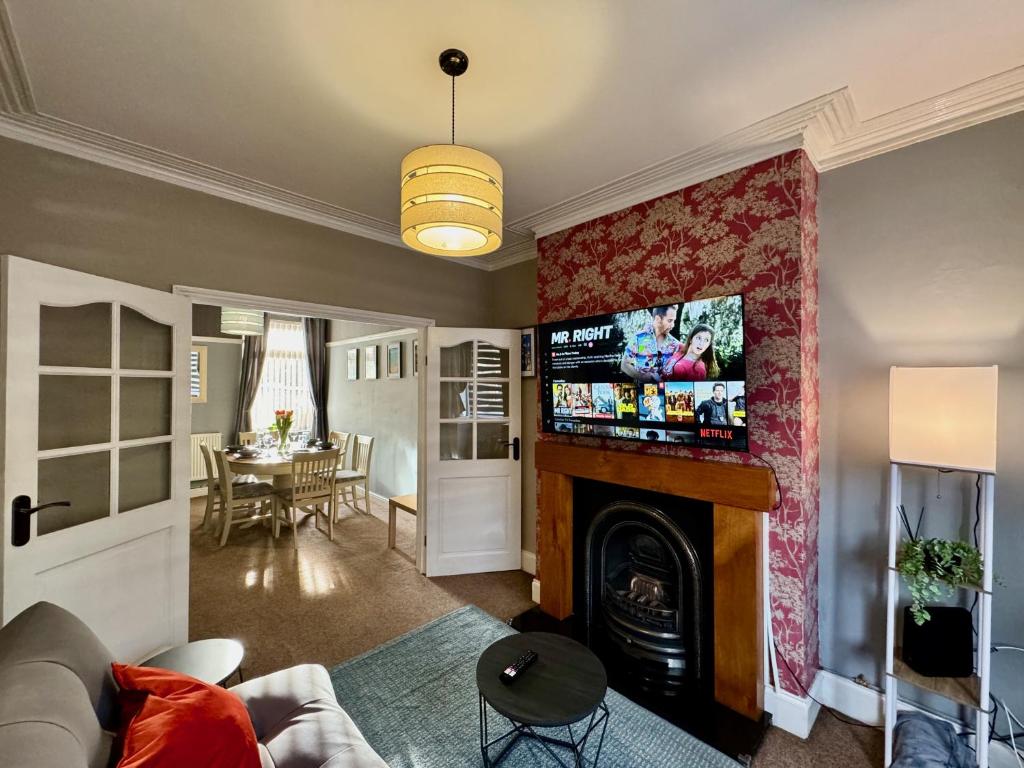a living room with a fireplace and a tv at Freeston House - Charm Townhouse in Cleethorpes