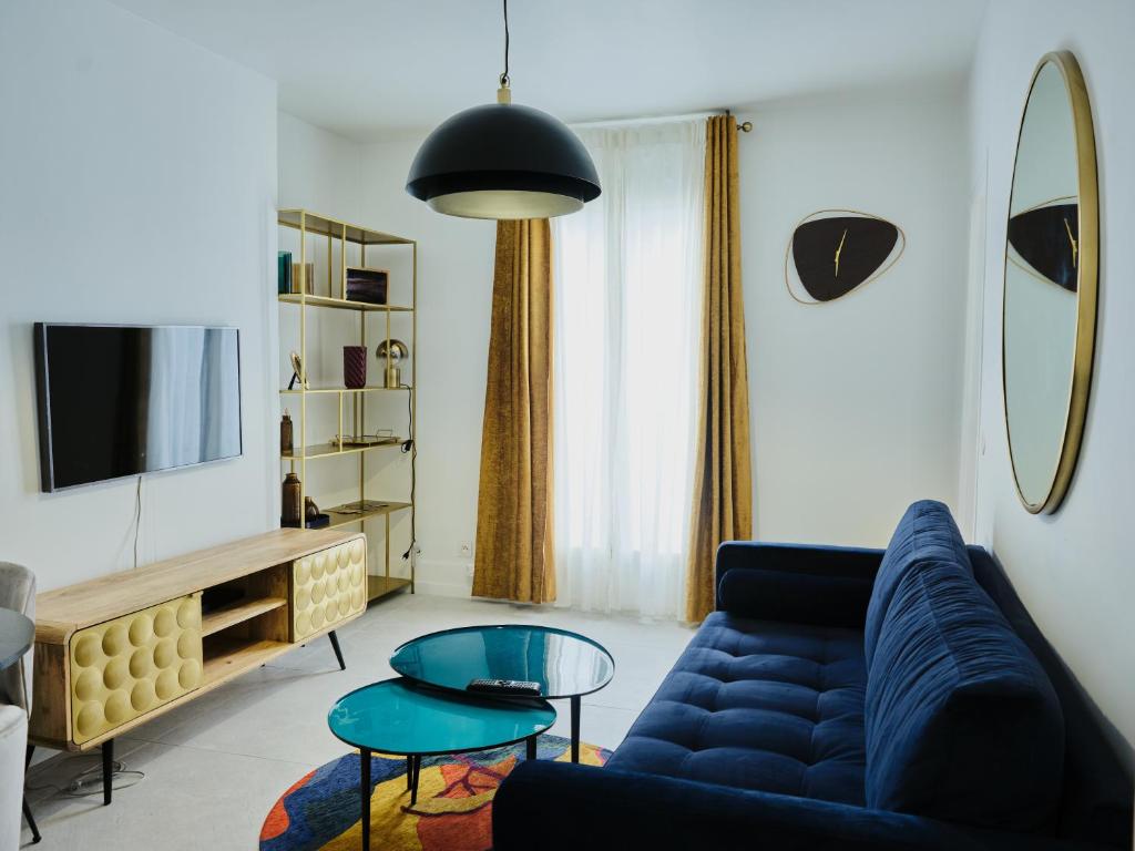 un salon avec un canapé bleu et une table dans l'établissement Bel appart au charme parisien, pour 6 personnes, à Paris