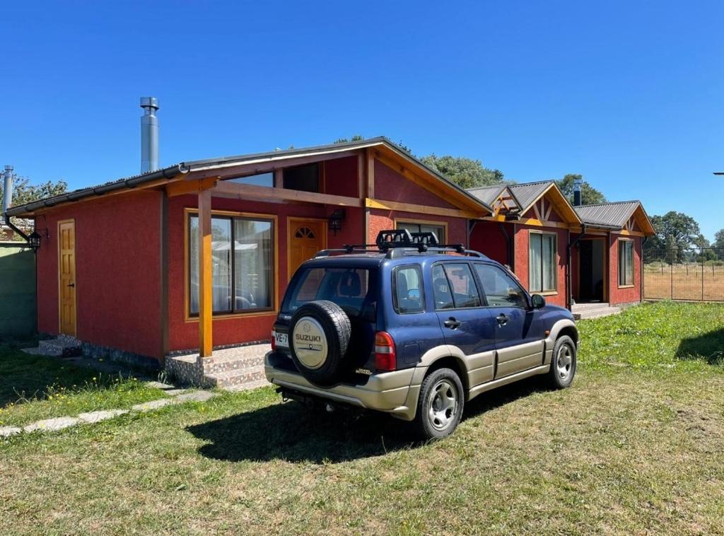 a blue suv parked in front of a house at Cabañas ruta internacional 215 I, Osorno in Osorno